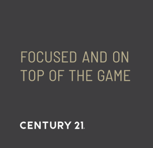 Century 21 branding slide with the phrase "Focused and On Top of the Game" in gold text on dark background.